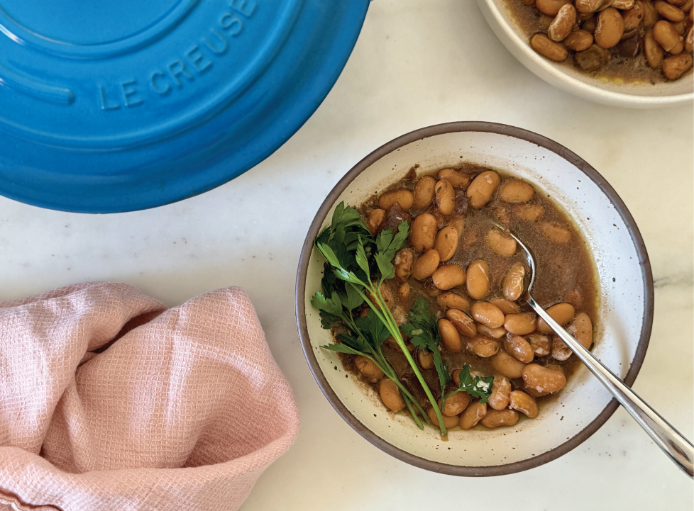 Pot of brothy beans with blue pot and pick napkin 